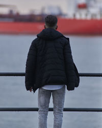 Rear view of man standing in city against sky