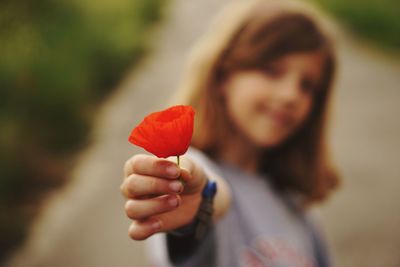 Close-up of woman holding red flower