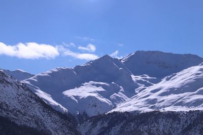 Scenic view of snowcapped mountains against blue sky
