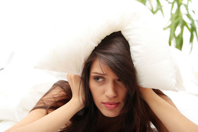 Portrait of beautiful young woman lying on bed
