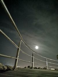 Low angle view of illuminated bridge against sky at night