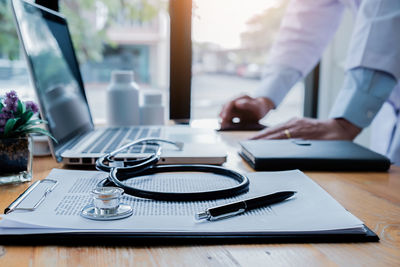 Midsection of man using laptop on table