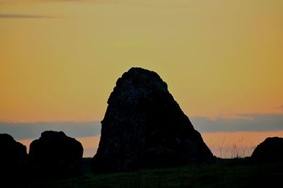 Silhouette rock formation against sky during sunset