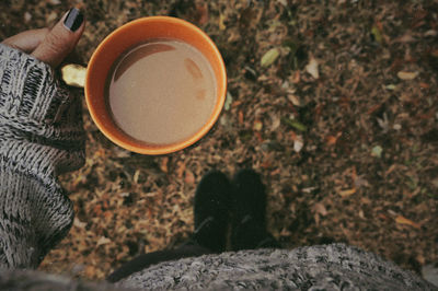 Low section of person holding coffee cup