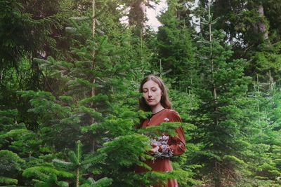 Portrait of young woman standing in forest