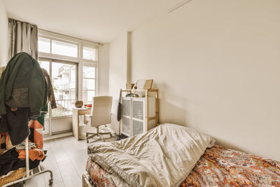 Young woman sitting on bed at home