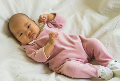 Cute baby lying on bed at home