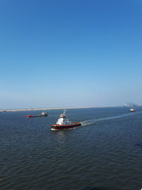 Ship sailing on sea against clear sky