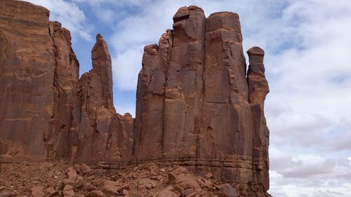 Low angle view of rock formation against cloudy sky