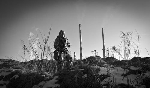 Soldier standing on snow covered field against sky