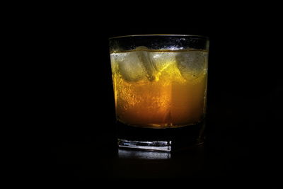 Close-up of beer glass against black background