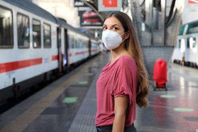 Woman standing at railroad station