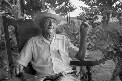 Portrait of man sitting by tree