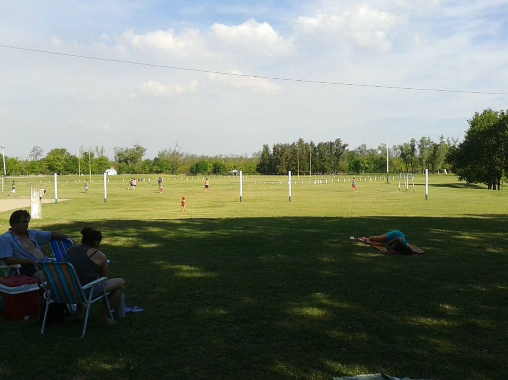 grass, tree, men, leisure activity, lifestyles, person, large group of people, sky, green color, field, sitting, relaxation, park - man made space, grassy, cloud - sky, sport, nature, day, outdoors