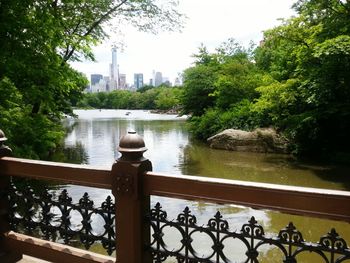 Scenic view of city by trees against sky