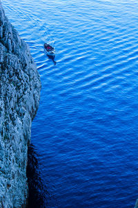 High angle view of man on rock by sea