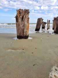 Old pier on beach against sky