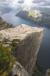 Hiker on majestic pulpit rock by fjord in lysefjorden, norway