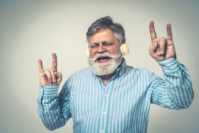 Young man standing against gray background