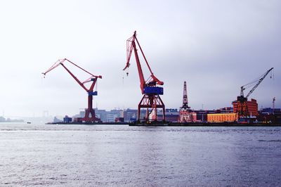 Cranes and industry front the river and bridge beyond in gothenburg 