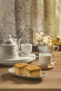 Coffee cup and cake on table