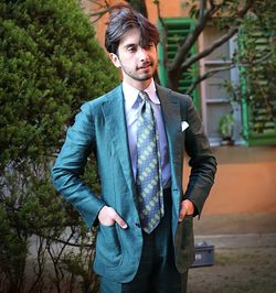 Portrait of young man standing against trees