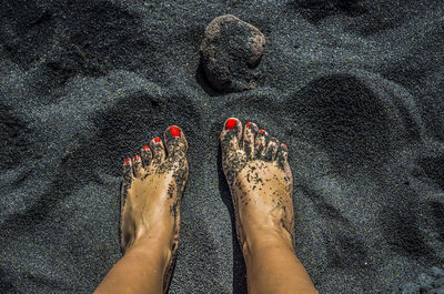 Low section of woman standing on sand