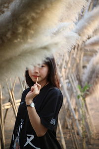 Side view of woman looking away while standing on field