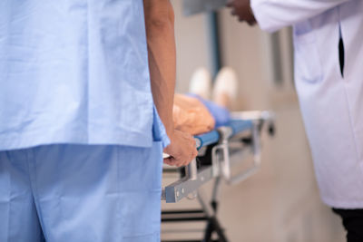 Midsection of doctors holding hands