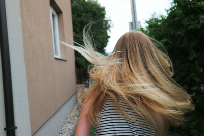 Woman with tousled hair standing outdoors