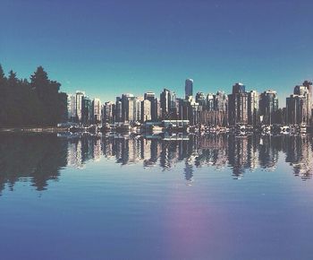 Buildings in city against clear blue sky