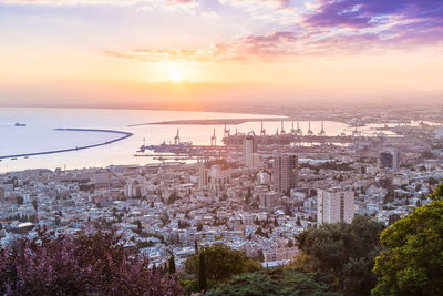 Aerial view of buildings in city during sunset