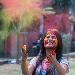 Close-up of smiling young woman smoking outdoors