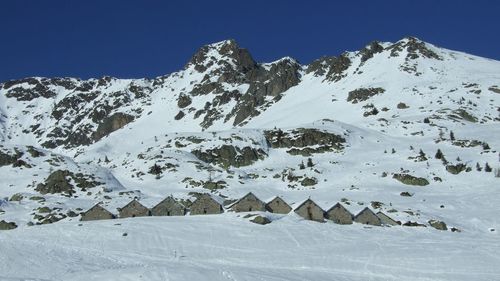 Scenic view of snowcapped mountains against clear sky