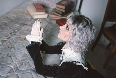 High angle view of woman praying at home