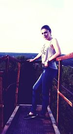 Portrait of young woman standing against sky