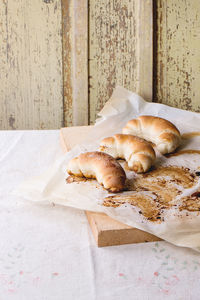 Croissants on wax paper over table