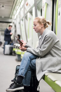 Side view of woman sitting in bus