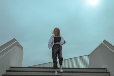 Low angle view of woman standing against building