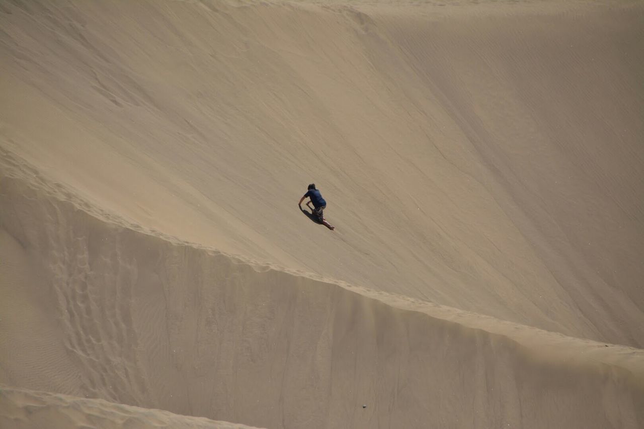 PERSON RIDING MOTORCYCLE ON SAND