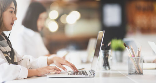 Businesswoman using laptop while working on table in office