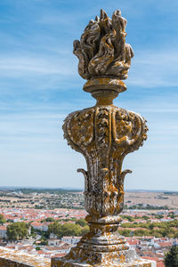 Close-up of statue with city in background