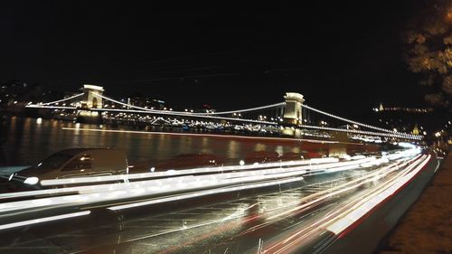 Suspension bridge over river at night