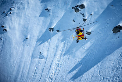 High angle view of airplane flying over snowy field