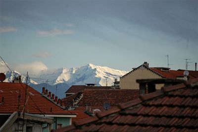 Houses on snowcapped mountains against sky