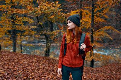 Full length of young woman standing in autumn