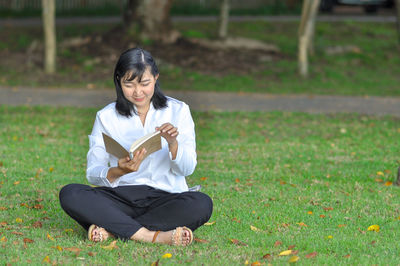 Full length of woman sitting on field