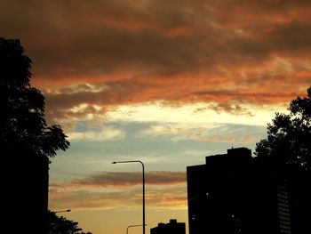 Low angle view of silhouette buildings against sky at sunset
