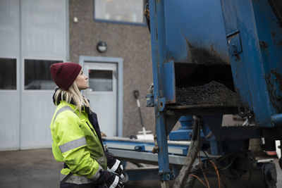 Young female construction worker operating machinery