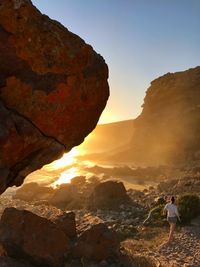 Rear view of woman standing on rock formation